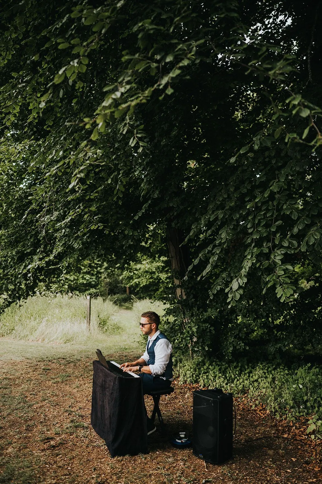 Finn playing a keyboard in a woodland clearing